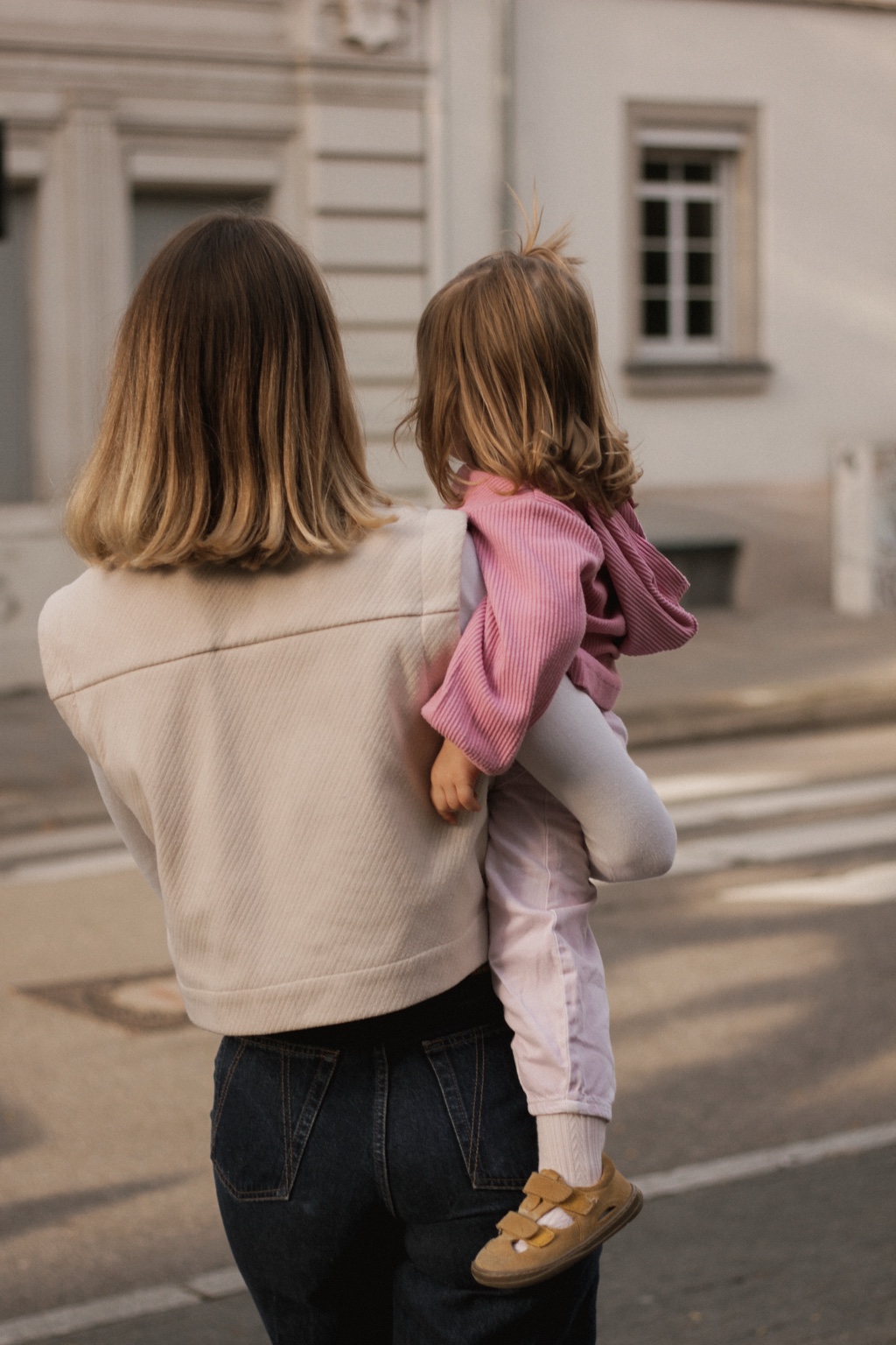 Mutter trägt ihre Tochter durch die Stadt